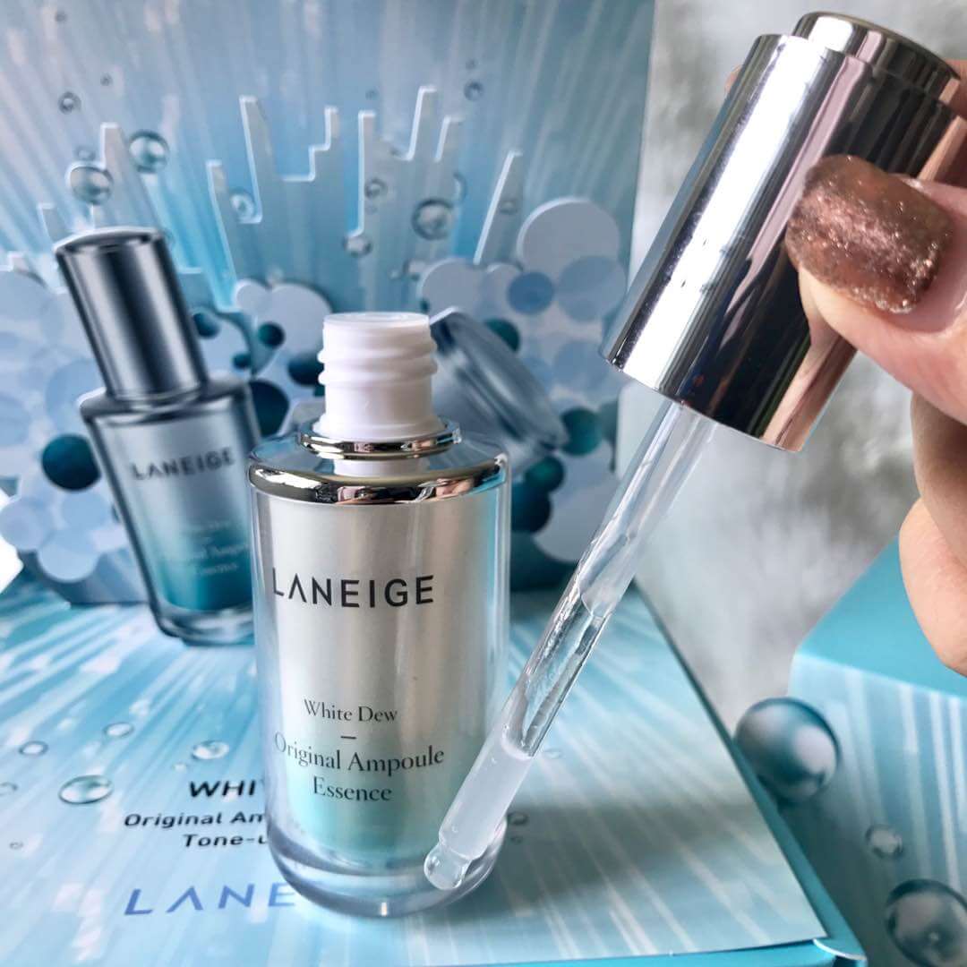 Laneige WHITE DEW Original Ampoule Essence 40ml หยดประกายสว่างใสไร้จุดด่างดำ ลดเลือนผิวหมองคล้ำ ให้เจิดจรัสดุจน้ำค้าง พร้อมเผยผิวชุ่มชื่นกระจ่างใสยิ่งขึ้น  มอยส์เจอร์ไวท์เทนนิ่งเอสเซนส์สูตรเข้มข้นสูงที่ช่วยปรับโทนสีผิวให้สว่างกระจ่างใส พร้อมตรงเข้าลดเลือนจุดด่างดำและเปลี่ยนให้กระจ่างใสจากภายใน ด้วยส่วนผสมทรงประสิทธิภาพสูตรเข้มข้น พร้อมมอบผลลัพธ์ผิวกระจ่างใสชุ่มชื่น  ตรงเข้าลดเลือนจุดด่างดำอย่างทรงประสิทธิภาพด้วย ไวท์เทนนิ่งเอสเซนส์สูตรเข้มข้น ด้วยการผสมผสานสารสกัดจาก Saururus chinensis และวิตามินซีสูตรเข้มข้นช่วยตรงเข้าลดเลือนจุดด่างดำให้กระจ่างใสยิ่งขึ้นจากภายใน  เนื้อสัมผัสบางเบาแต่เข้มข้น ซึมซาบล้ำลึก มอบผลลัพธ์ความชุ่มชื้นสูงสุดให้ผิวทันทีที่ใช้ ด้วยส่วนผสมของเอสเซนส์สูตรเข้มข้น ช่วยมอบผลลัพธ์ผิวชุ่มชื่นล้ำลึก ให้ผิวกระจ่างใส อิ่มน้ำ ทันทีที่ใช้